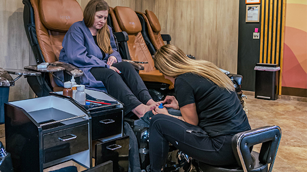 A woman gives another woman a pedicure at the spa.